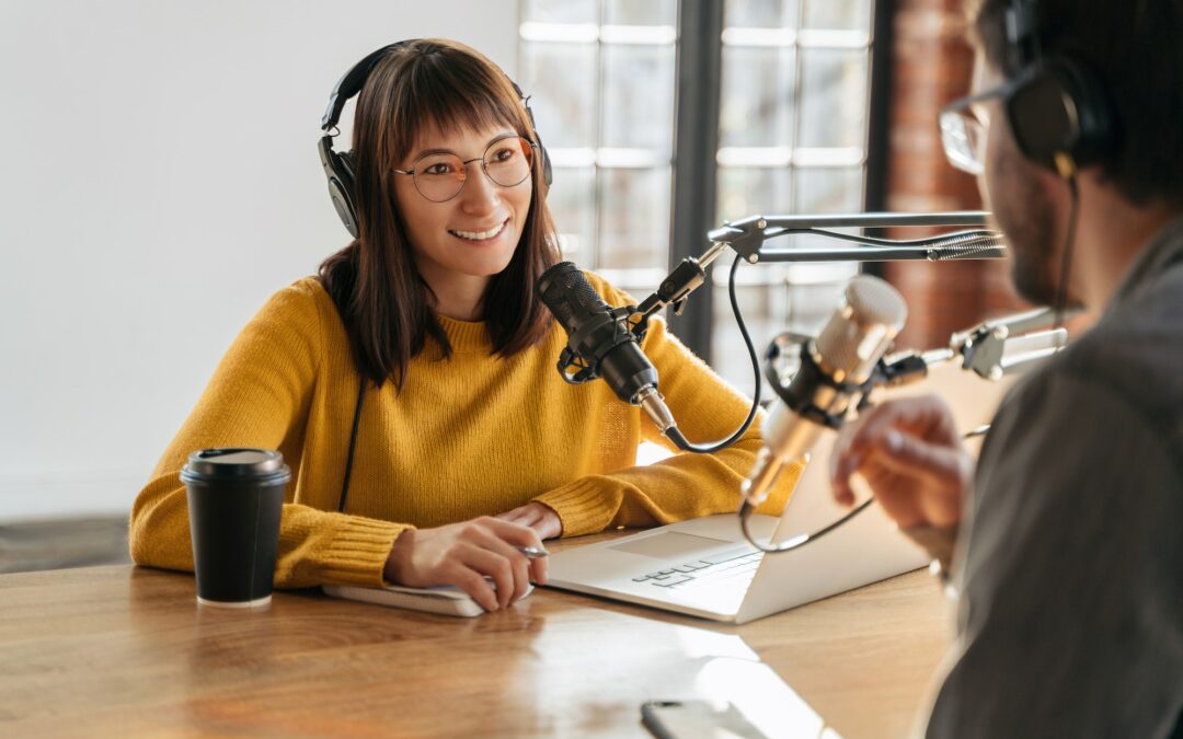 Man and woman podcasters interview each other for audio podcast in studio