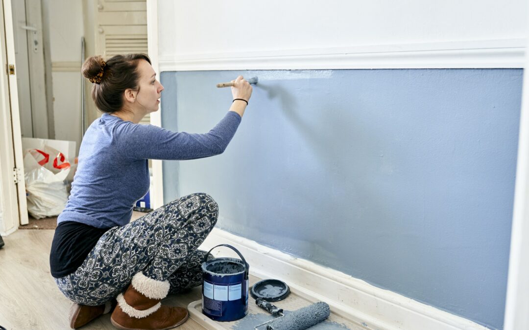 Woman painting wall at home.